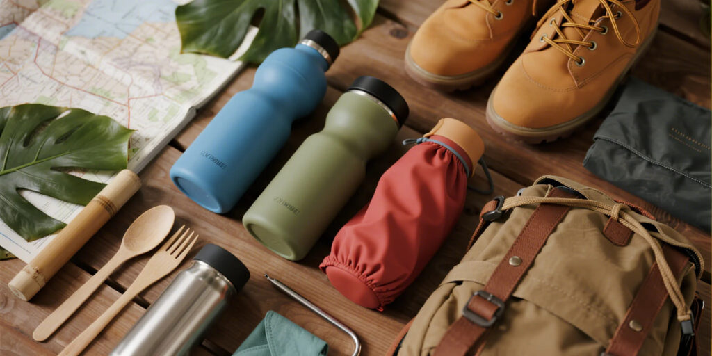 Reusable silicone water bottles folded and packed for travel with eco-friendly gear.